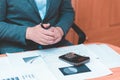 Toned Cropped image of businessman calculating invoice at desk in office