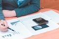 Toned Cropped image of businessman calculating invoice at desk in office