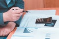 Toned Cropped image of businessman calculating invoice at desk in office