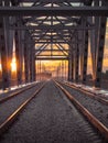 Toned image of the railway with sleepers and rail bridge on a background of multicolored sunset