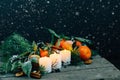 Toned image with snow flake Christmas composition Tangerines, Pine cones, Walnuts and Candles on Wooden Background, holiday