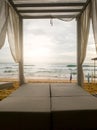 Toned image of sunbed under canopy at luxurious beach resort at ocean