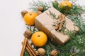 Toned instagram image wrapping rustic eco Christmas gifts with craft paper, string, tangerines and natural fir branches on white