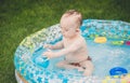 Toned image of adorable baby boy playing in inflatable swimming pool with ball Royalty Free Stock Photo