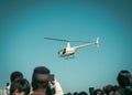 Toned photo hands taking photo hovering helicopter drops colorful eggs and goodies at Easter event in Richardson, Texas