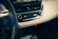 Toned photo highest temperate heat setting with knobs, digital display inside modern leather car interior, defrost mode fan at Royalty Free Stock Photo