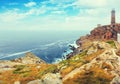 Toned photo with the lighthouse on the rocky coast Royalty Free Stock Photo