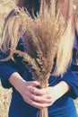 Toned photo with long haired blondy young woman with bunch of wood small-reed. Concept