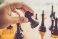 Toned photo of man making move with black horse at chess game Royalty Free Stock Photo