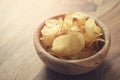Toned photo of potato chips with herbs in wood bowl on rustic table Royalty Free Stock Photo