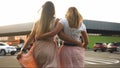 Toned photo of two girls friends hugging while walking on car parking at shopping mall Royalty Free Stock Photo