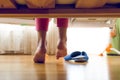 Toned image from under the bed on young girl in pajamas searching for slippers Royalty Free Stock Photo