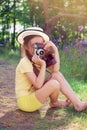 Toned portrait of Cute little girl in retro outfit taking pictures with old film camera. Royalty Free Stock Photo