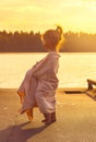 Toned portrait of Cute little girl is watching at the sea at sunset