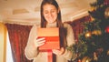 Toned portrait of happy smiling woman looking inside of Chrsitmas gift box Royalty Free Stock Photo