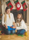 Toned portrait of smiling girl with mother packing pullover in p