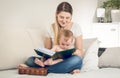 Toned portrait of smiling mother looking at photo album with her Royalty Free Stock Photo