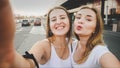 Toned selfie photo for social media of two smiling girls on car parking at shoping mall Royalty Free Stock Photo