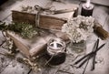 Toned still life with black candles, old books and flowers on planks