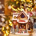 Toned vintage image of adorable christmas music toy house with miniature santa presents decorated tree bokeh background Royalty Free Stock Photo