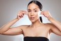 Toner can help you achieve that perfectly poreless look. Studio portrait of a beautiful young woman using a cotton pad Royalty Free Stock Photo