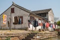 Filthy white house with laundry along canal in Tongli, China