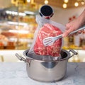 With tongs the chef puts the vacuumized meat into with for low temperature cooking Royalty Free Stock Photo