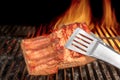 Tongs Holding Grilled Pork Ribs