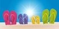 Holiday concept with the flip flops of a family planted in the sand. Royalty Free Stock Photo