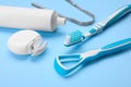 Tongue cleaners and other oral care products on light blue background, closeup Royalty Free Stock Photo