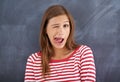 Tongue out, blackboard and portrait with woman, teacher and education with knowledge and silly. Face, funny and goofy Royalty Free Stock Photo