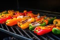tongues of flame licking chopped bell peppers on the grill