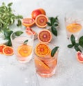 Tonic nonalcoholic mocktail with red Sicilian oranges and ice, grey background. Cold refreshing summer mojito lemonade Royalty Free Stock Photo