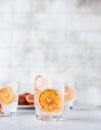 Tonic nonalcoholic mocktail with red Sicilian oranges and ice, grey concrete background. Cold refreshing summer mojito lemonade Royalty Free Stock Photo