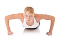 Toning through body weight exercises. Portrait of a determined young woman doing push-ups against a white background. Royalty Free Stock Photo