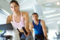 Toning those legs. A man and woman exercising in spinning class at the gym. Royalty Free Stock Photo