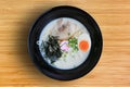 Tonkotsu Ramen Asian noodles with chashu Pork, seaweed and boiled egg in black bowl on bamboo wooden background, top view Royalty Free Stock Photo