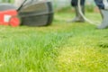 Tonsured lawn and the red lawn mower/lawn mower is cleaned from a grass. Selective focus Royalty Free Stock Photo