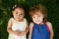 Too cute. High angle portrait of two little girls lying on the grass. Royalty Free Stock Photo