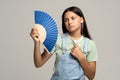 Sweaty teenage girl using paper fan suffer from heat cooling in hot summer weather Royalty Free Stock Photo