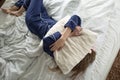 Too lazy to get out of bed, a woman covers her face with a pillow.