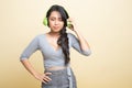 Too loud.  portrait of  young asian woman  holding  headphones and making unhappy face Royalty Free Stock Photo