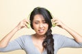 Too loud.  portrait of  young asian woman  holding  headphones and making unhappy face Royalty Free Stock Photo