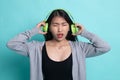 Too loud.  portrait of  young asian woman  holding  headphones and making unhappy face Royalty Free Stock Photo