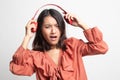 Too loud.  portrait of  young asian woman  holding  headphones and making unhappy face Royalty Free Stock Photo