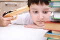 Too much information concept, a boy kid sitting at the desk and holding a toy gun, tired of reading concept