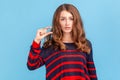 Too small. Portrait of dissatisfied woman in striped casual sweater showing a little bit gesture