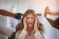 Too stressed out to focus. an anxious looking businesswoman surrounded by hands reaching in holding office items.