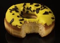 took a bite from a donut. Yellow cream with chocolate pieces.