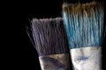 A tool for the artist`s work. Two brushes in paint close-up on a black background. Royalty Free Stock Photo